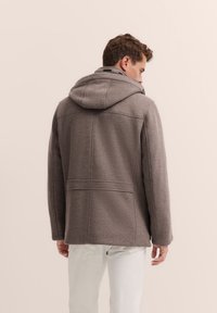 Grau melierter Wollmischmantel mit Kapuze, der ein sauberes Design, eine gerade Silhouette und sichtbare Nähte aufweist. Über leichten Hosen getragen.