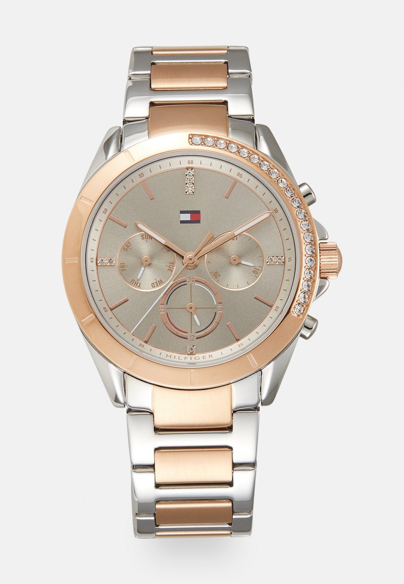 Reloj inteligente en tono oro rosa y plateado con una esfera redonda, banda metálica, acentos de cristal y un dial gris texturizado que presenta tres subdiales.