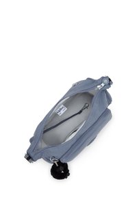 Borsa a tracolla Kipling di colore azzurro chiaro con zip aperta, clip interna per le chiavi e portachiavi a forma di scimmia nera pelosa attaccato.