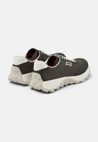 Zapatillas deportivas para hombre de color gris oscuro con un upper de tela texturizada, acentos en blanco y una suela de goma rugosa de color claro. Cuentan con cordones deportivos y acolchado en el interior.