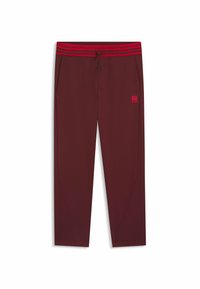 Burgundy sweatpants with a red-striped elastic waistband. Features side pockets and a small embroidered logo on the left thigh.