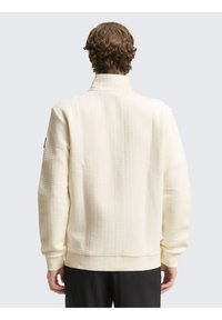 Crème-kleurige, gestructureerde sweatshirt met een hoge kraag en geribbelde boorden. Eenvoudig ontwerp, met minimalistische naden en geen zichtbare logo's.