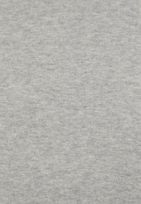 Tela gris claro con una textura suave y acanalada, que presenta un sutil patrón jaspeado en toda la superficie. Sin costuras o acentos visibles.