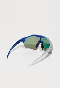 Sport-Sonnenbrille mit einem blauen Kunststoffrahmen, grün getönten Gläsern und einer silbernen Nase. Hat eine verlängerte Form und strukturierte Seiten.