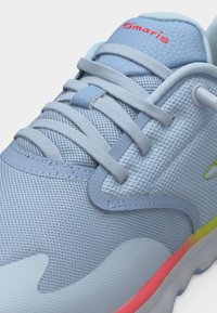 Αθλητικό παπούτσι Tamaris ανοιχτού γαλάζιου χρώματος με διχτυωτό επάνω μέρος, κορδόνια στο ίδιο χρώμα και λεπτομέρεια στη σόλα με βαθμιαία μετάβαση από κίτρινο σε ροζ, εικονιζόμενο σε κοντινή γωνία.