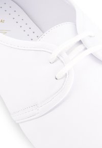 Witte leren veterschoen met ronde neus, zichtbare stiksels en geperforeerde binnenzool voor ademend vermogen.