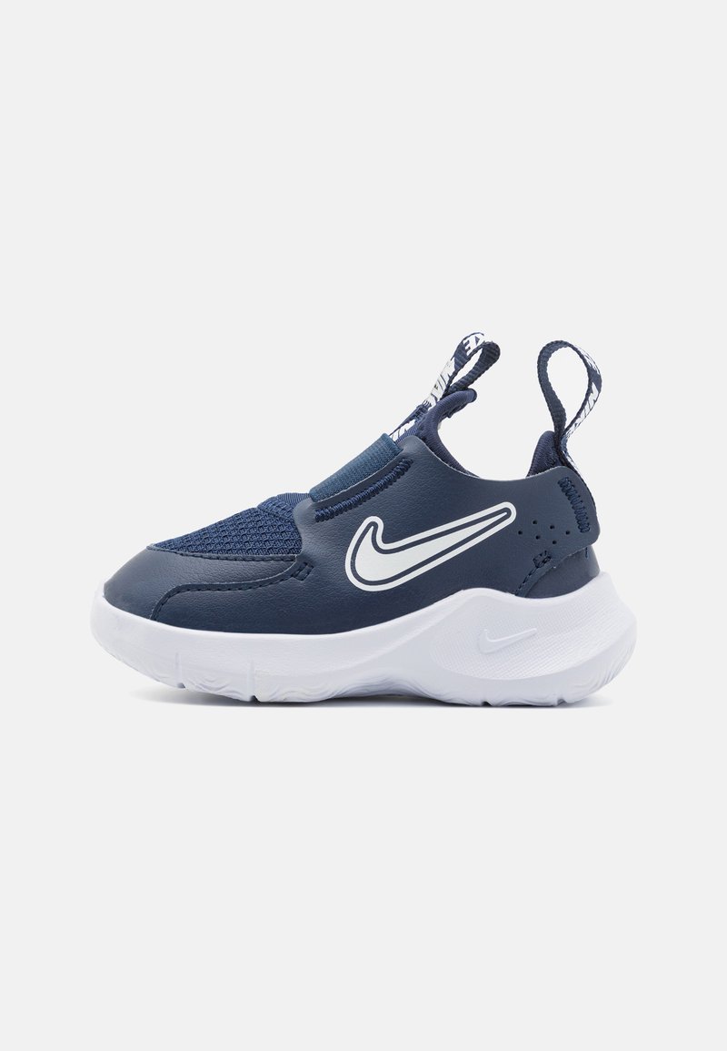 Námornícky modré slip-on tenisky s vrchom z jemného sieťovina a syntetiky, biela podrážka a výrazné biele logo Nike swoosh. Obsahuje úchyty pre jednoduchšie obúvanie.