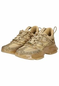 Zapatillas beige con malla texturizada y embellishments brillantes, que cuentan con una suela transparente gruesa y un sistema de cordones integrado.
