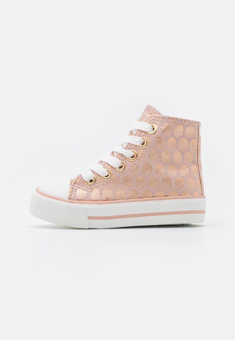 Bottine haute rose en matériau doux, ornée d'un motif à pois, avec des lacets blancs, des œillets dorés et une semelle en caoutchouc blanche avec un accent rose.