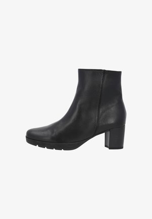 Bottine noire en cuir avec un bout rond, texture lisse, détails de couture sur le côté, et un talon épais pour plus de stabilité.
