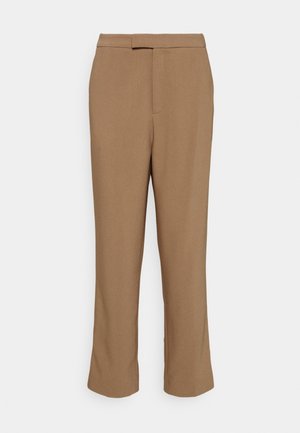 Pantalon marron sur mesure à jambes droites avec un pli frontal et une ceinture, sur un fond uni.