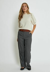 Cream puff-sleeve top paired with gray tailored trousers. The outfit features a brown belt with a round buckle and black flats.