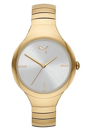 Złoty zegarek na rękę z srebrną tarczą, złotymi wskazówkami godzinową, minutową i sekundową, minimalistycznymi indeksami godzin oraz logo Puma na godzinie 12.