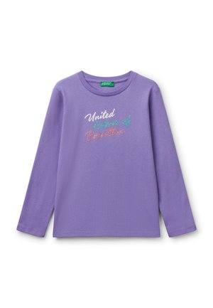 Chemise à manches longues, de couleur lilas clair, en coton doux. Présente le texte "United Colors of Benetton" en lettres multicolores pailletées.