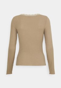 Långärmad, figurnära topp i beige ribbat tyg. Har en scallop-nacke med detaljer och en mjuk textur, med en enkel design.