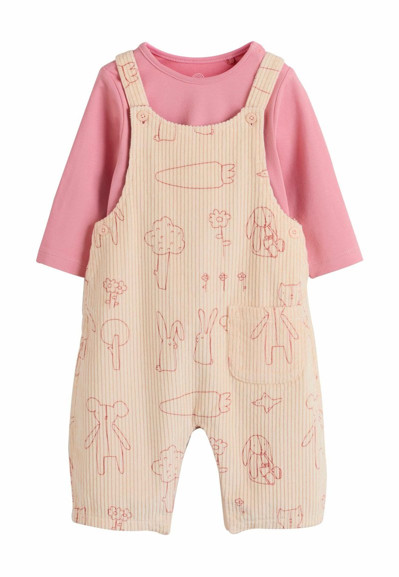 Roze lange mouwen shirt onder beige corduroy tuinbroek met rode lijntekeningen van wortels, dieren, bomen, bloemen en een voorkantzak.