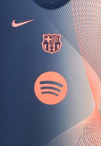 Jersey de Nike en azul oscuro con acentos en rosa. Presenta el logo de Barcelona y el icono de Spotify; textura suave con detalles en patrón diagonal.