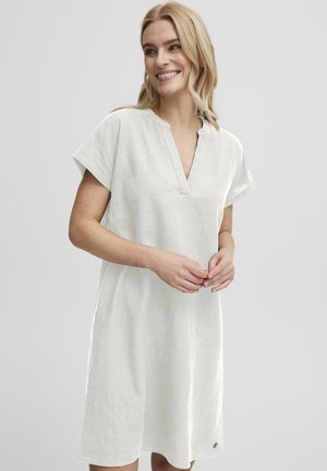 Leinenkleid in hellbeige, mit V-Ausschnitt, kurzen Ärmeln und lockerer Passform. Ein bemerkenswertes Detail ist ein kleines Logo am Saum.