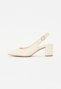 Beige slingback pump dengan ujung bulat, gesper yang dapat disesuaikan, dan tumit blok rendah. Tekstur halus dengan sedikit rincian.