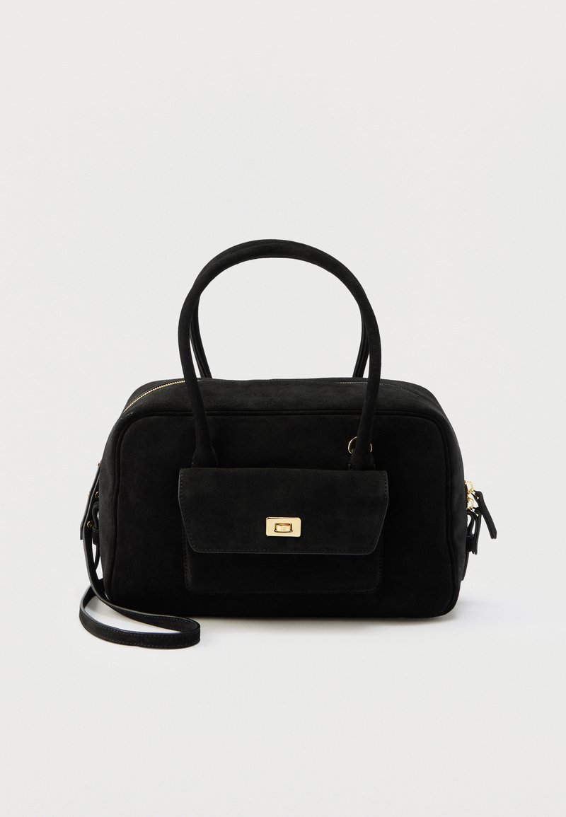 Μαύρη τσάντα από σουέντ με δύο λαβές, εμπρόσθια τσέπη με κλειδαριά με χρυσή συστροφή και αποσπώμενο ιμάντα ώμου, τοποθετημένη σε λευκό φόντο.