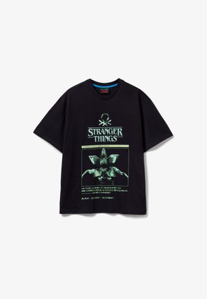Czarna bawełniana koszulka z zielonym nadrukiem przedstawiającym Demogorgona oraz tekstem "Stranger Things". Krótkie rękawy i luźny krój.