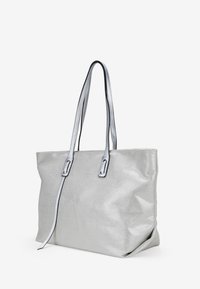 Bolso tote plateado hecho de tela metálica, con dos asas largas, un diseño espacioso y una textura suave con un ligero brillo.