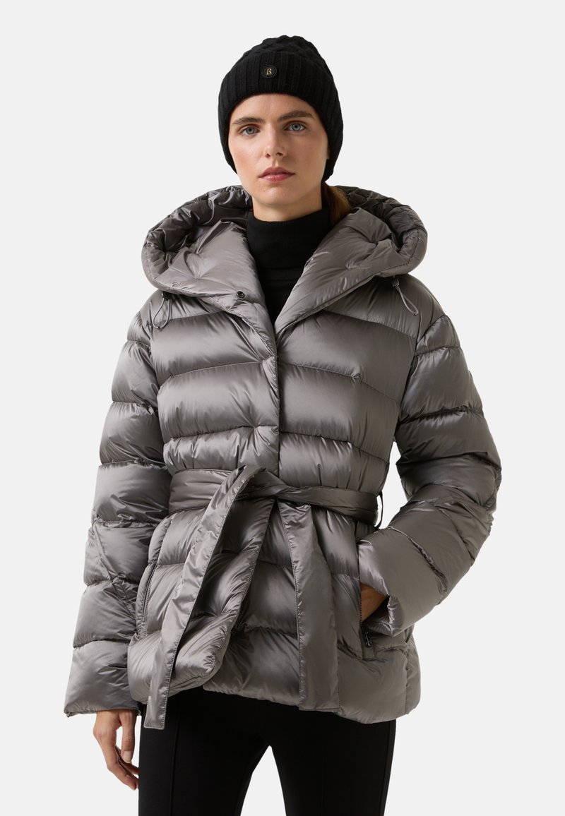 Grå puffjakke med hætte, indsnævret talje og vandret quiltet design. Stoffet ser glansfuldt ud; har et bælte og lynlåslommer.