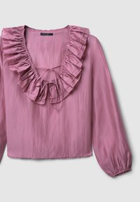 Blusa rosa con scollo arricciato, maniche lunghe con polsini elastici e un tessuto leggermente testurizzato. Fiocchi davanti per la regolazione.