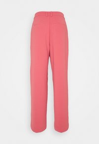 Růžové kalhoty na míru se střihovými nohavicemi, vyrobené z hladké tkaniny. Obsahují dvě zadní kapsy a středně vysoký pas.