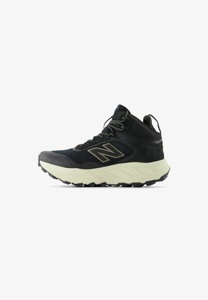 Black athletic boots with mesh upper, reinforced toe, and contrasting light sole. Features gray laces and logo. Textured for grip.