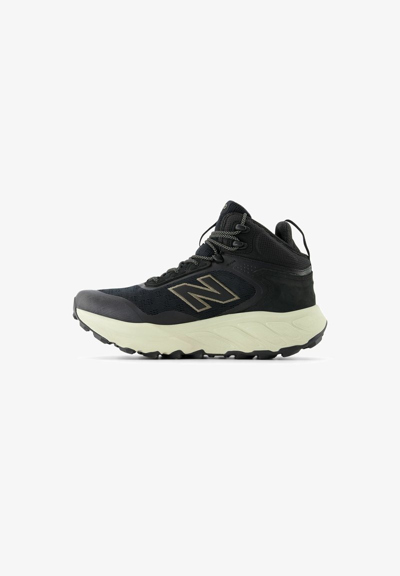 Black athletic boots with mesh upper, reinforced toe, and contrasting light sole. Features gray laces and logo. Textured for grip.