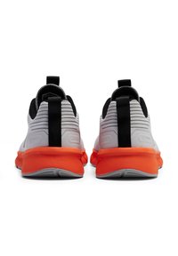 Grijze gebreide hardloopschoenen met een gestructureerde afwerking, zwarte accenten en een oranje zool. Voorzien van een lusje voor gemakkelijk aan- en uittrekken.