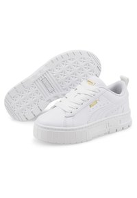 Baskets blanches en cuir vegan avec un bout rond, semelle en caoutchouc épais, lacets plats et accent logo doré. Tige texturée et semelle à motifs.
