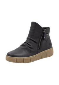 Bottine en cuir noir avec une finition texturée, fermeture à glissière sur le côté, et une semelle en caoutchouc beige, épaisse, avec un motif segmenté.