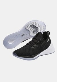 Mustat urheilukengät, joissa on tekstuuripinta, nauhakiristys ja valkoinen pohja, jossa on ainutlaatuinen kuviointi. Suunnittelu on kevyttä ja hengittävää.