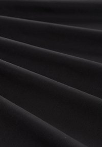 Schwarzer Stoff mit einer glatten, matten Textur. Zeigt subtile diagonale Linien und Falten, die ein weiches, langlebiges Gewebe zur Schau stellen.