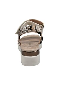 Damensandalen mit Schlangenlederprint, beigen und schwarzen Riemen, beiger Fußbett und weißer Plateausohle. Verstellbarer Knöchelriemen enthalten.
