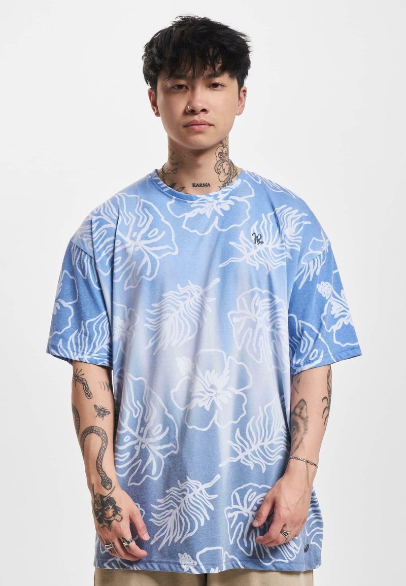 Light blue short-sleeved T-shirt featuring white floral patterns, with a relaxed fit and soft texture. Includes a small logo on the chest.