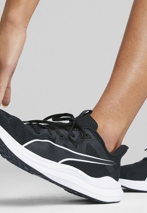Scarpa da ginnastica nera con tomaia in rete, dettagli bianchi e suola imbottita. Presenta un design con lacci e dettagli testurizzati.