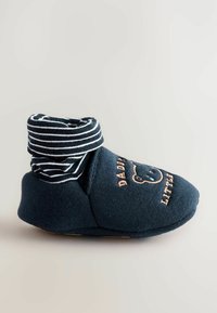 Marinblå babytossor med randig uppvikt fåll. Mjuk tyg med björnbroderi och texten "Pappas lilla." Flekibelt sula.