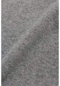 Gråt strikket stof med en blød tekstur og et subtilt mønster. Materialet virker let og let strakt.