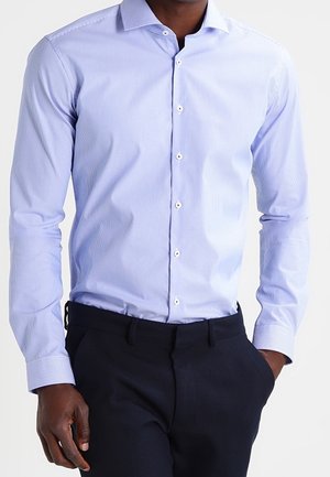 Lichtblauw, gestreept overhemdd met lange mouwen, knoopsplitstype kraag en witte knopen, gecombineerd met donkere broek. Vriendelijke textuur.