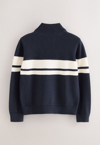 Tmavomodrý pletený sveter s vysokým golierom, s bielymi a čiernymi vodorovnými pruhmi na hrudi a rebrovanými manžetami a lemom.
