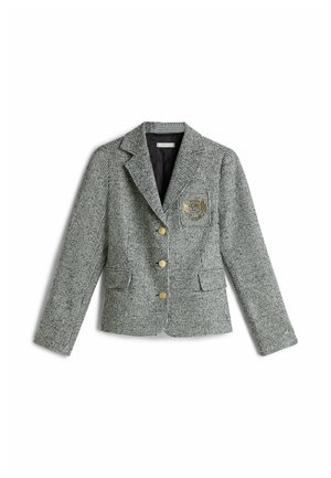 Blazer pied-de-poule gris et blanc avec trois boutons dorés et un blason doré brodé sur la poche poitrine gauche, doublure intérieure noire.