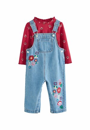 Denim-Trägerkleid mit floraler Bestickung in Pink, Rot und Grün auf der Vorderseite; kombiniert mit einem roten gerippten Oberteil mit einem rüschigen Ausschnitt und floralem Muster.