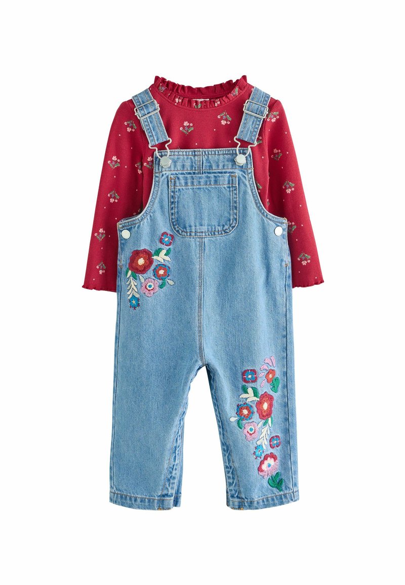 Denim-Trägerkleid mit floraler Bestickung in Pink, Rot und Grün auf der Vorderseite; kombiniert mit einem roten gerippten Oberteil mit einem rüschigen Ausschnitt und floralem Muster.
