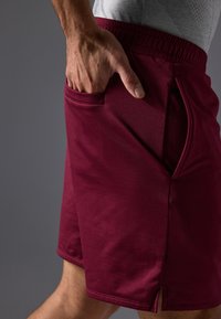 Μαρόν αθλητικές βερμούδες με ελαστική μέση, πλαϊνές τσέπες και λεία υφή. Διαθέτουν πλαϊνές σχισμές στο στρίφωμα για ευκολία κίνησης.