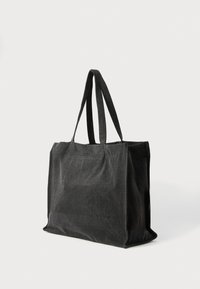 Fekete vászontáska két masszív fogantyúval, téglalap alakú, puha tapintású, minimalista kivitelű. Mindennapi használatra alkalmas.