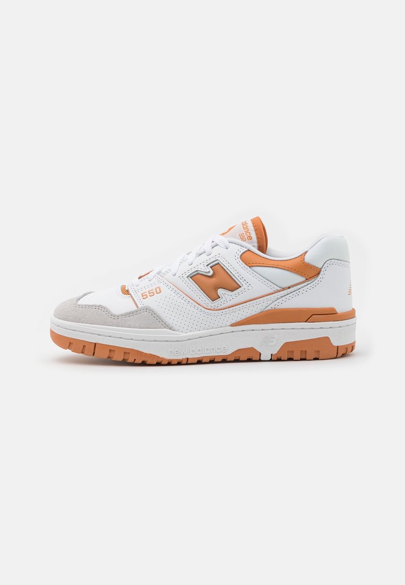 Zapatilla blanca de cuero con acentos en naranja, paneles laterales perforados, una punta de ante gris y una suela de goma gruesa con un dibujo en el relieve.