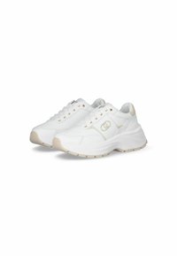 Baskets blanches en cuir lisse avec une semelle épaisse, présentant des accents beiges subtils et des détails dorés près des lacets.